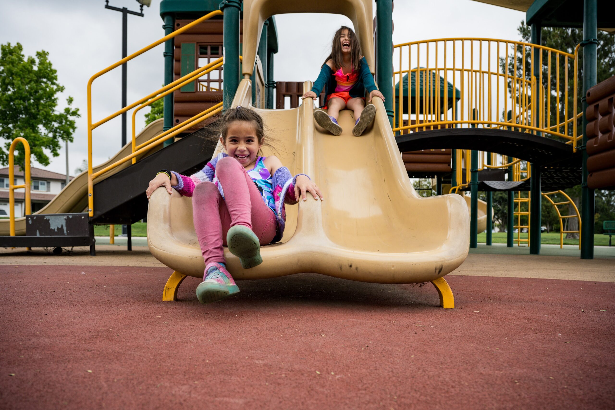 Two kids playing on a slide