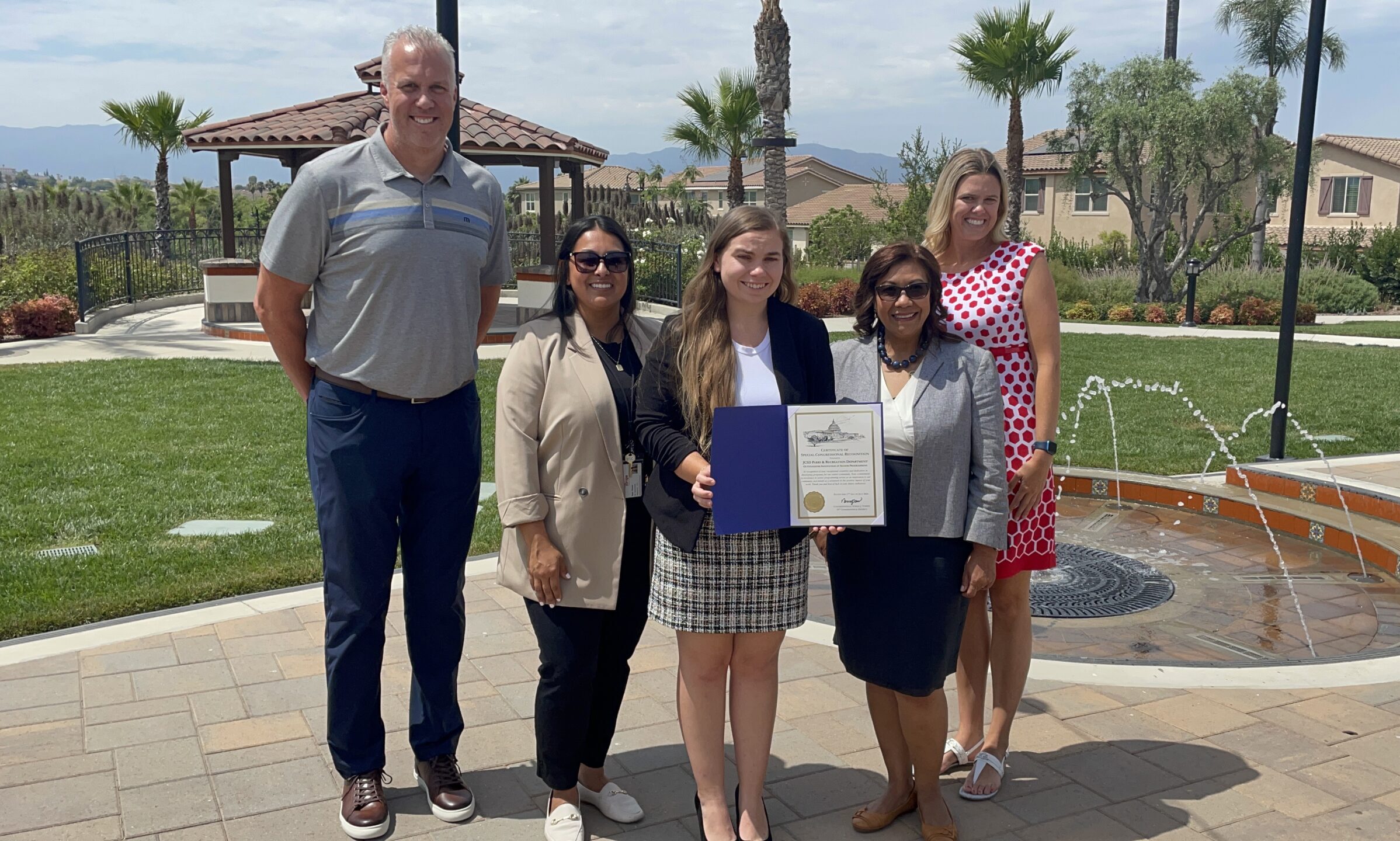 Image of Congresswoman Norma Torres with JCSD Staff holding certificate